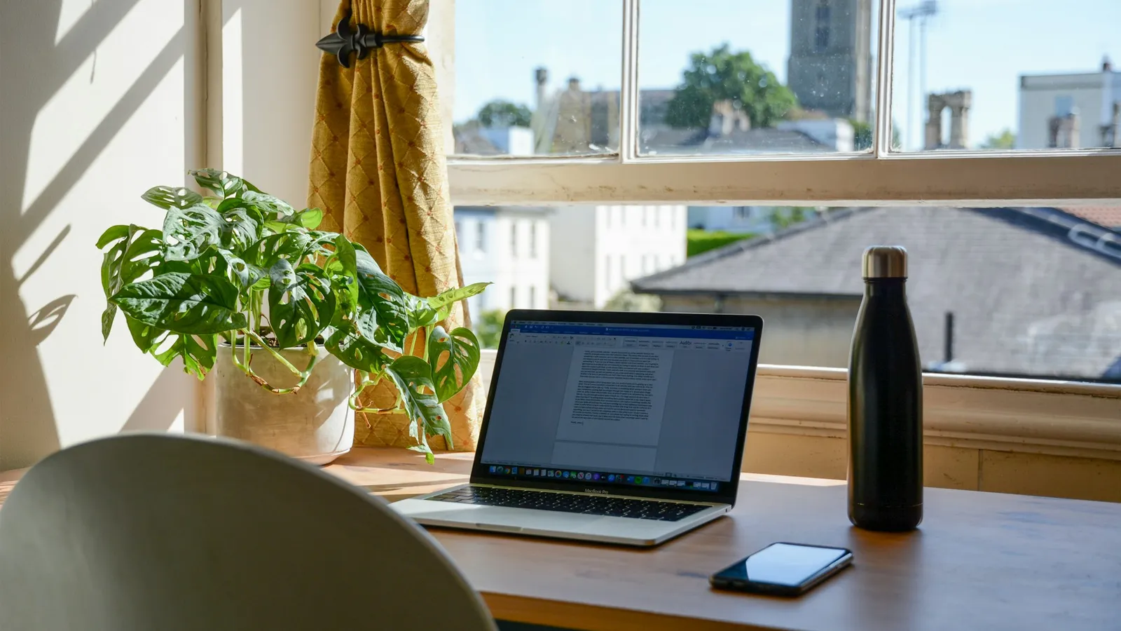 Bureau clair avec un ordinateur portable, pour nous écrire